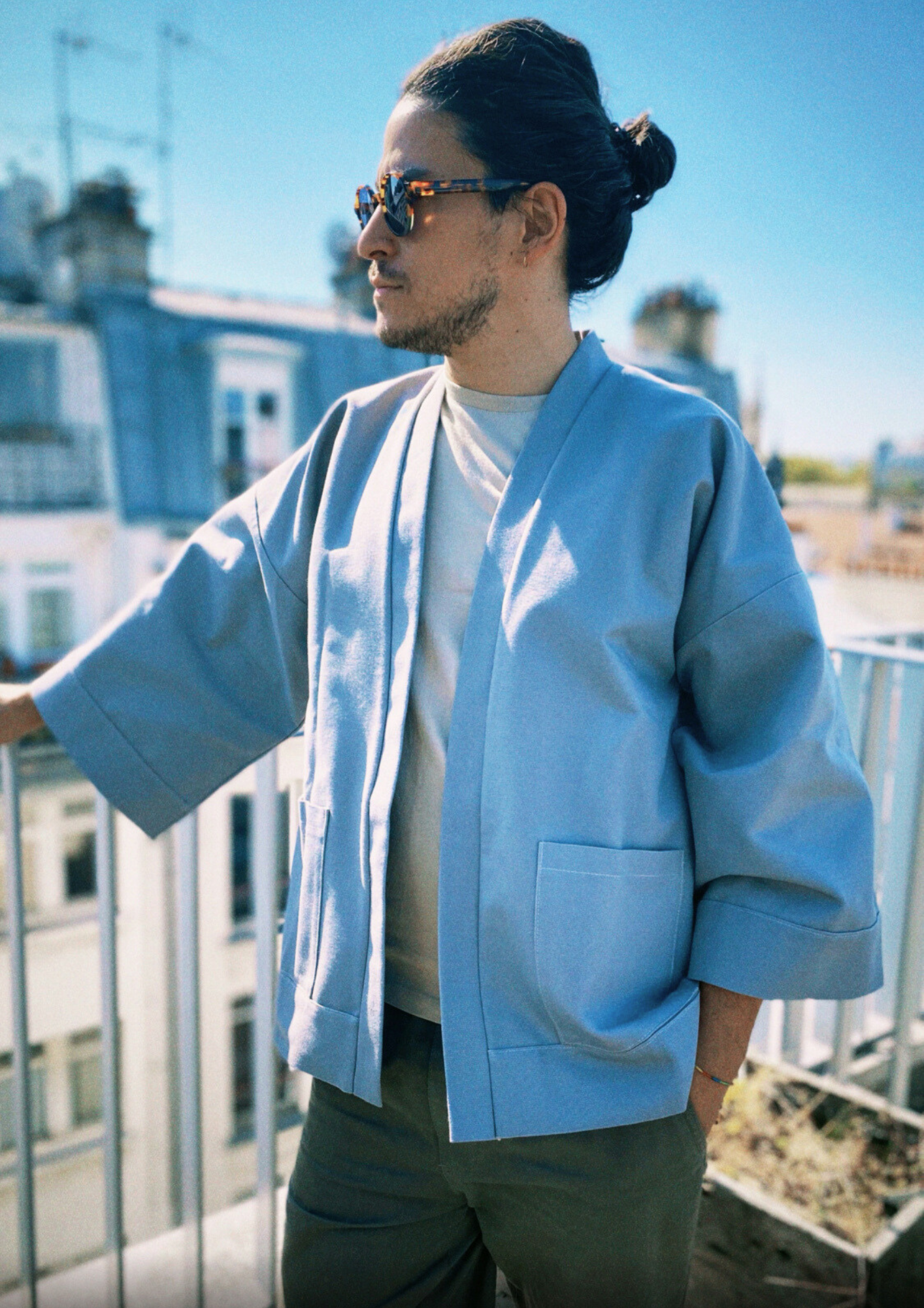 Homme portant un kimono gris en coton biologique, coupe ample avec ceinture. Pièce confectionnée à la main à Paris, par Atelier Sarita.