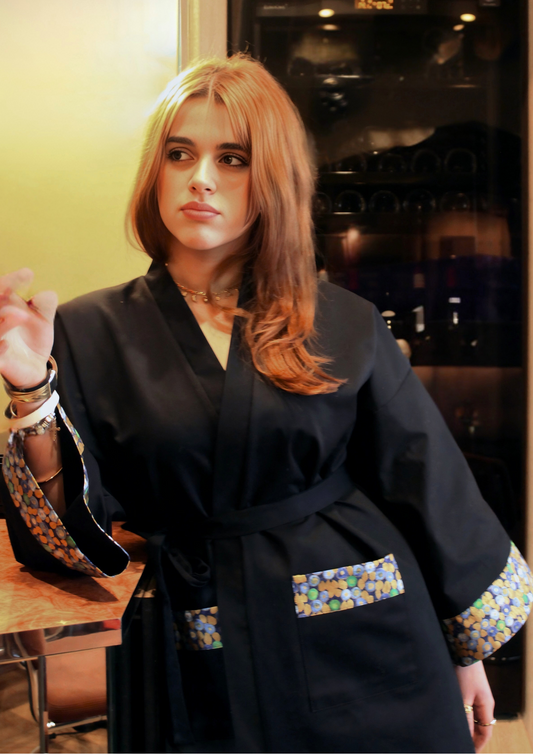 Jeune femme portant un kimono bleu avec finitions colorées sur les manches et les poches. Fabrication artisanale à Paris.