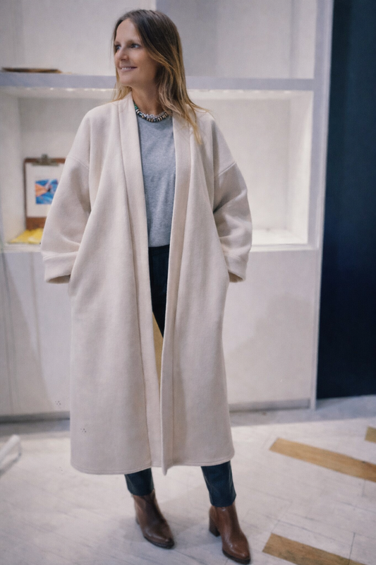 Femme portant un manteau kimono long en laine blanche. Une pièce élégante et contemporaine, fabriquée à la main, à Paris, en série très limitée. 