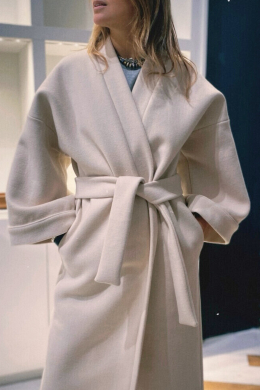 Femme portant un manteau kimono long en laine blanche. Une pièce élégante et contemporaine, fabriquée à la main, à Paris, en série très limitée. 