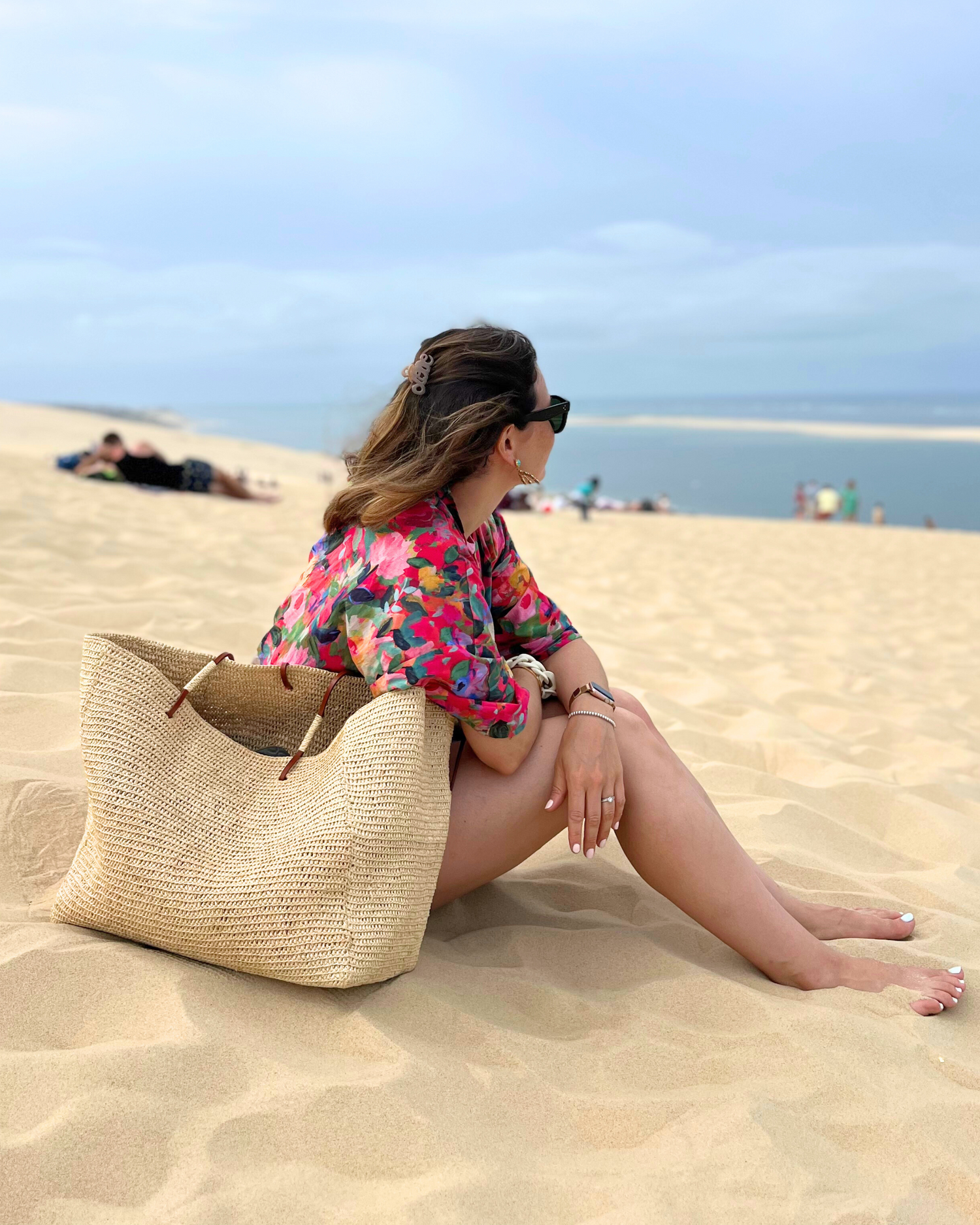 Caroline, cliente d'Atelier Sarita se prélasse sur la plage avec son kimono en coton fleuri et nous témoigne de l'élégance de cette pièce intemporelle en toute circonstance. 