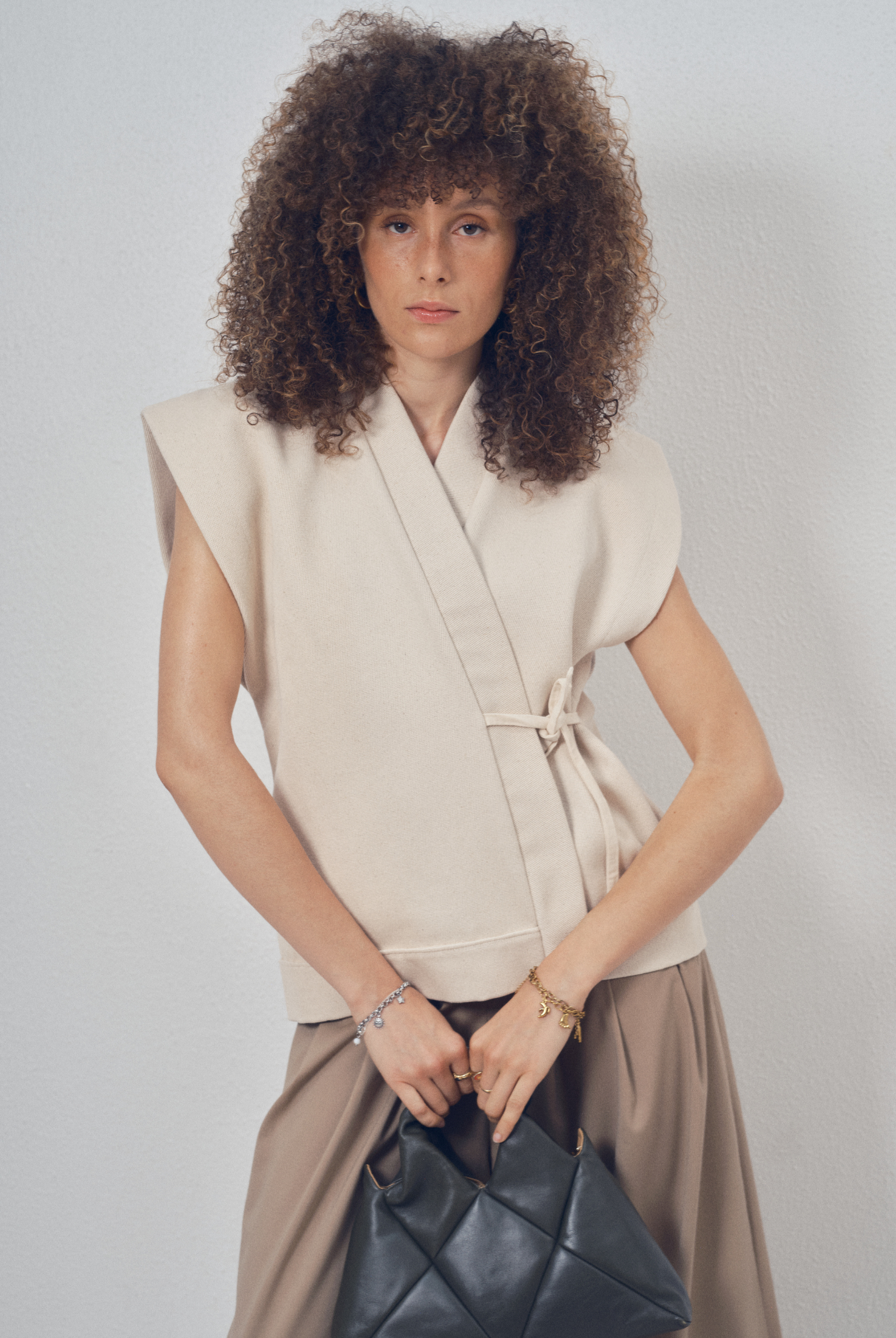 Pièce sans manches écrue aux lignes kimono portée sur un pantalon ample beige, modèle Claude de la collection Côté Marais par Atelier Sarita