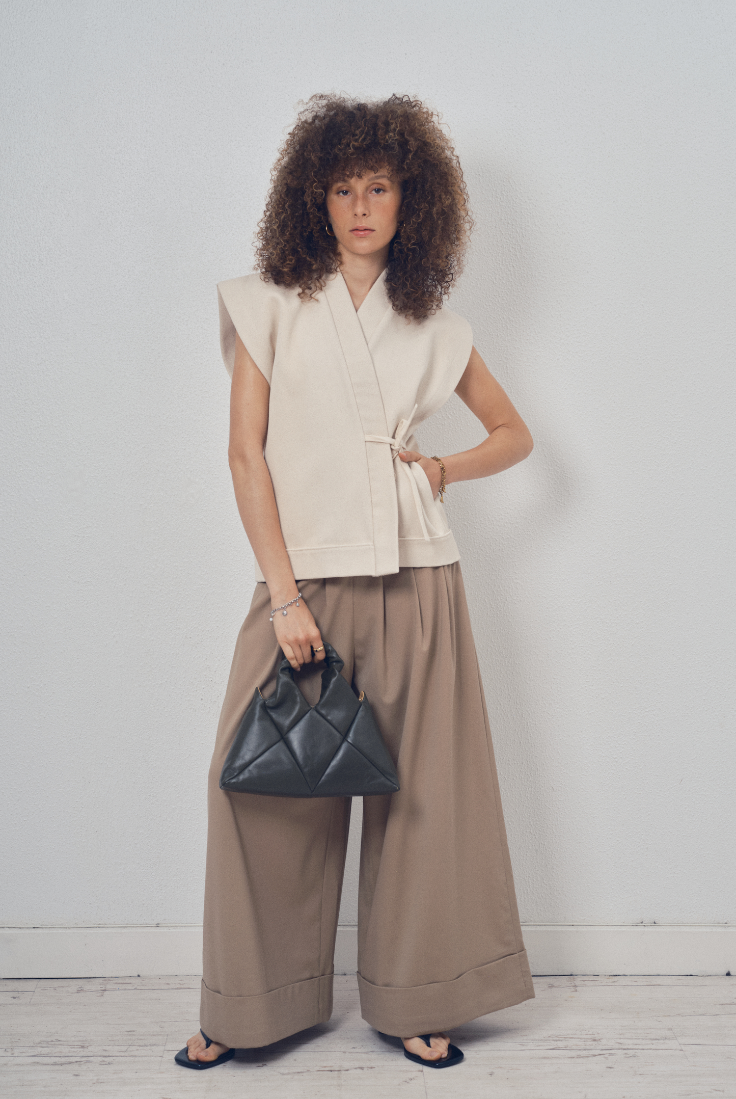 Pièce sans manches écrue aux lignes kimono portée sur un pantalon ample beige, modèle Claude de la collection Côté Marais par Atelier Sarita
