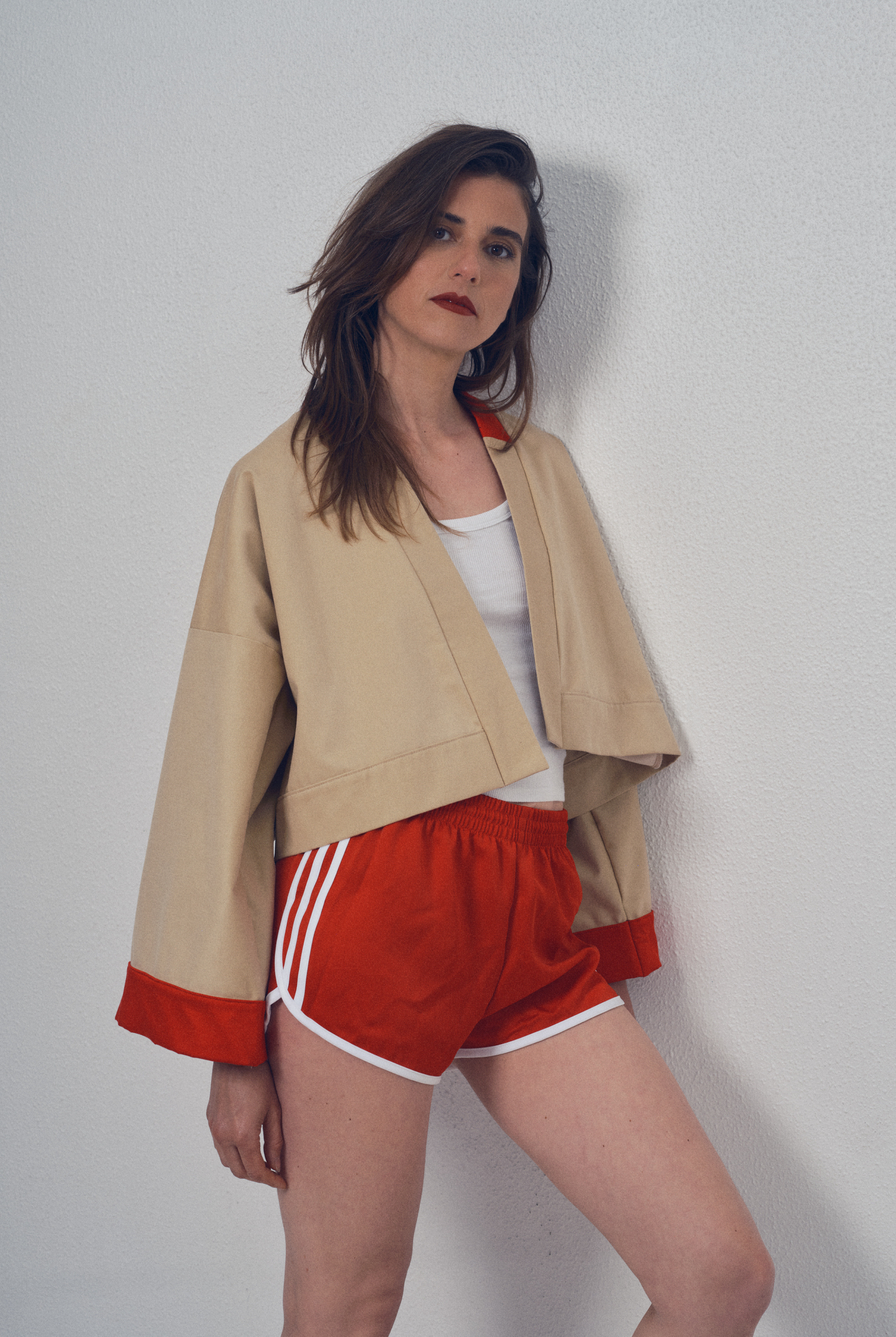 Veste crop beige et rouge aux lignes kimono portée avec un short rouge, modèle Gilles de la collection Côté Marais par Atelier Sarita.