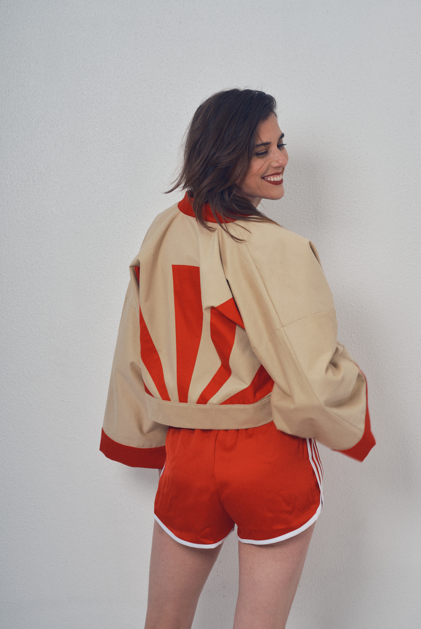 Veste crop beige et rouge aux lignes kimono portée avec un short rouge, modèle Gilles de la collection Côté Marais par Atelier Sarita.