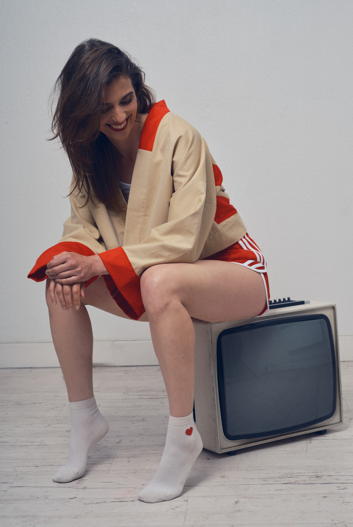 Veste crop beige et rouge aux lignes kimono portée avec un short rouge, modèle Gilles de la collection Côté Marais par Atelier Sarita.