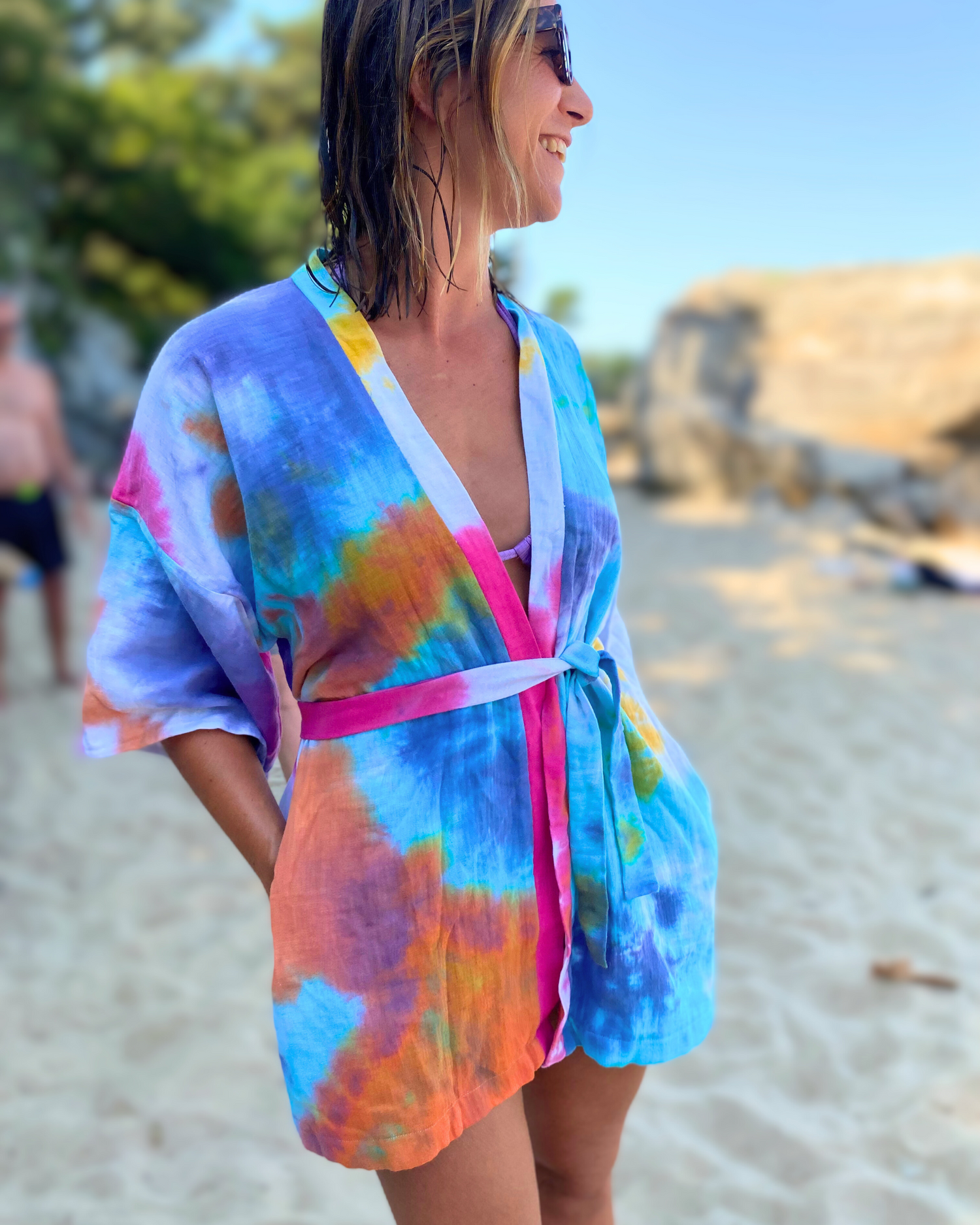 Kathleen, cliente fidèle d'Atelier Sarita, porte son kimono en gaze de coton tie and dye en sortie de bain sur la plage. 