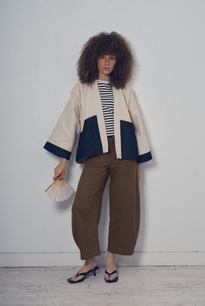 Veste courte écrue et denim noir aux lignes kimono portée avec un pantalon clair, modèle Simon de la collection Côté Marais par Atelier Sarita.