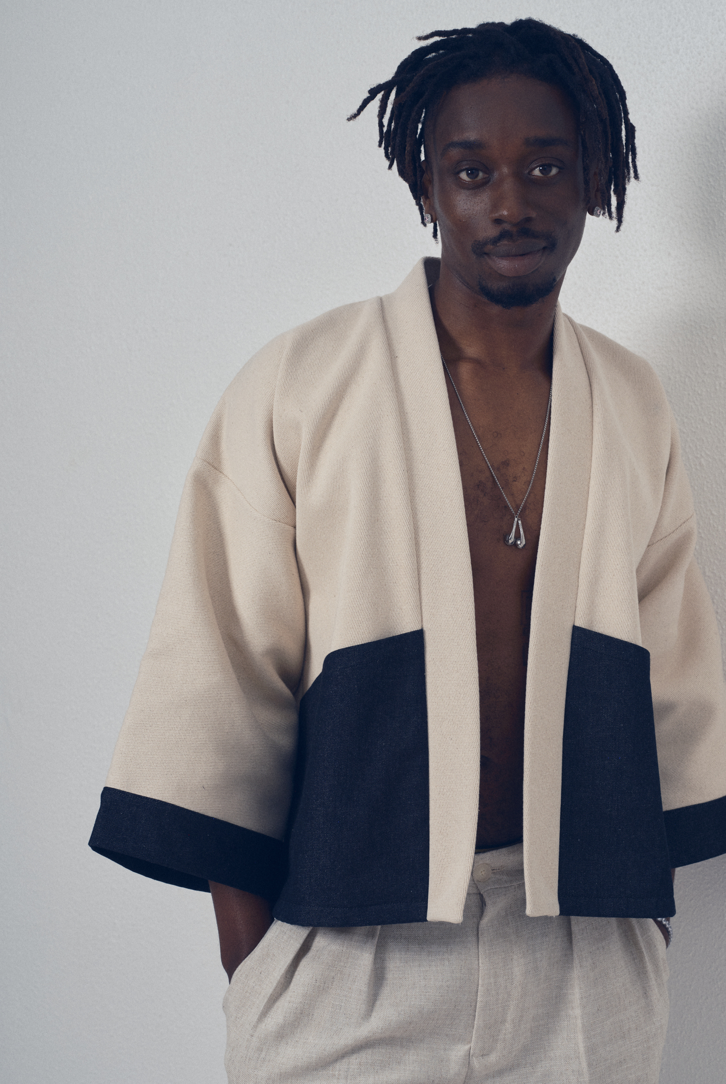 Veste courte écrue et denim noir aux lignes kimono portée avec un pantalon clair, modèle Simon de la collection Côté Marais par Atelier Sarita.