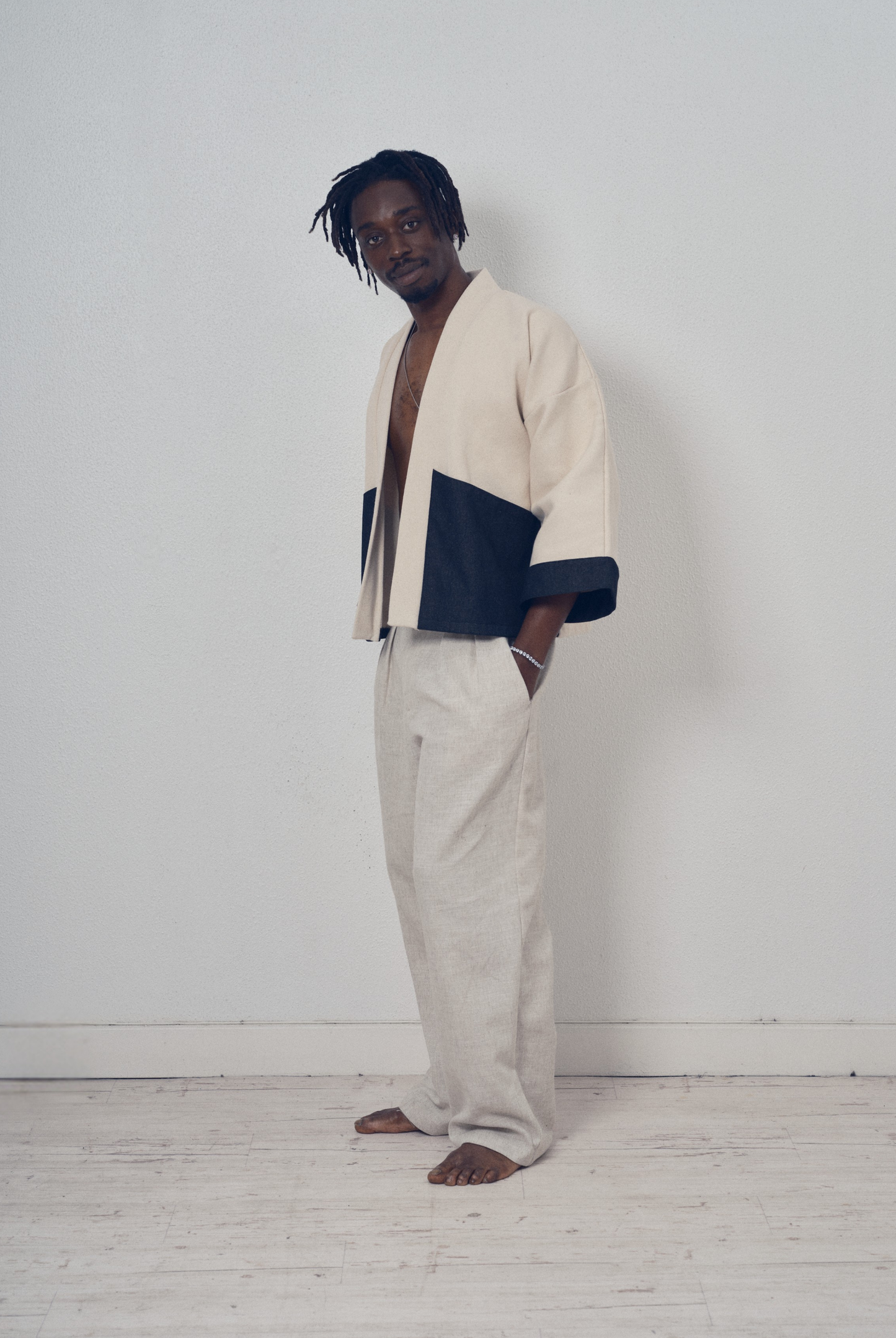 Veste courte écrue et denim noir aux lignes kimono portée avec un pantalon clair, modèle Simon de la collection Côté Marais par Atelier Sarita.