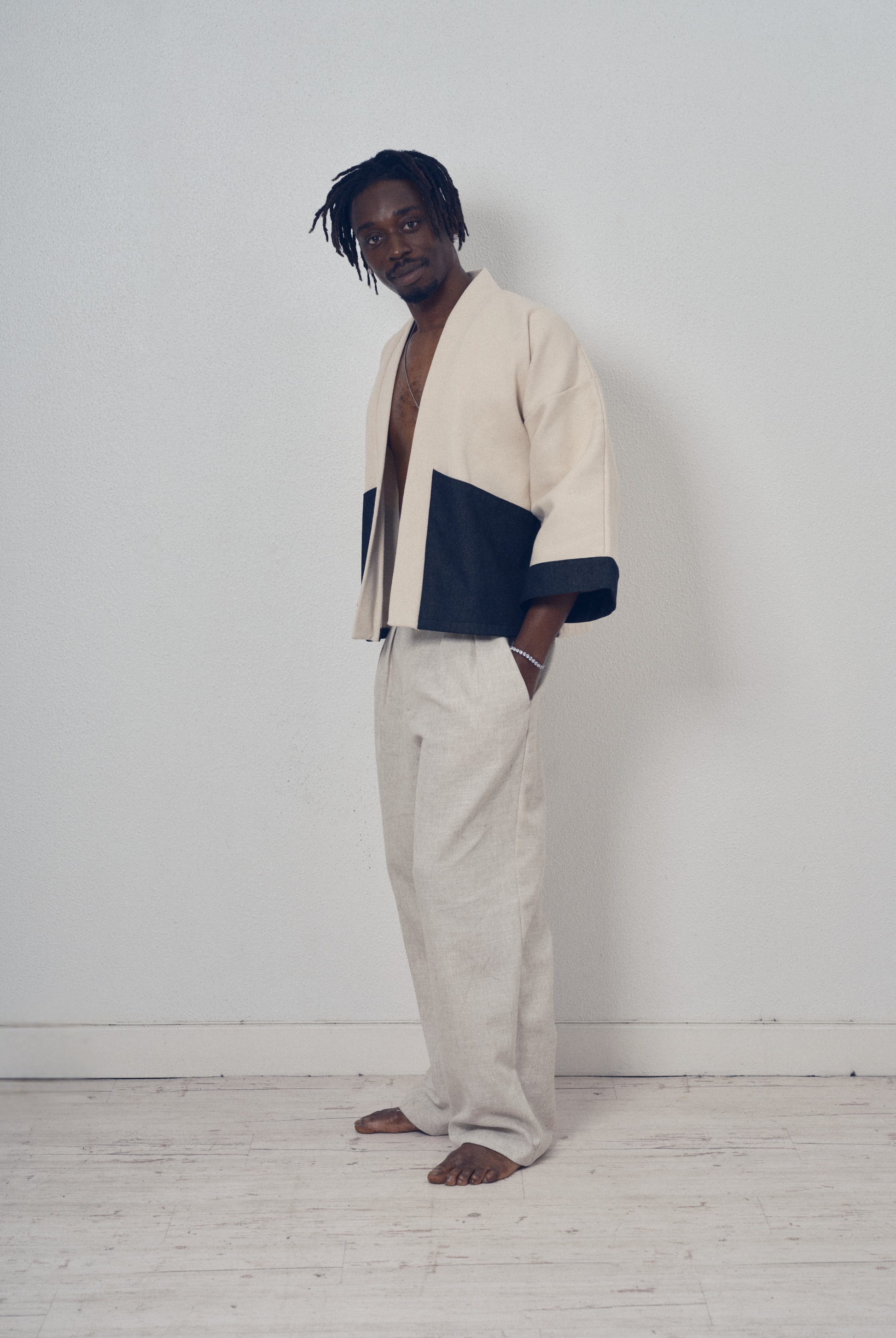 Veste courte écrue et denim noir aux lignes kimono portée avec un pantalon clair, modèle Simon de la collection Côté Marais par Atelier Sarita.